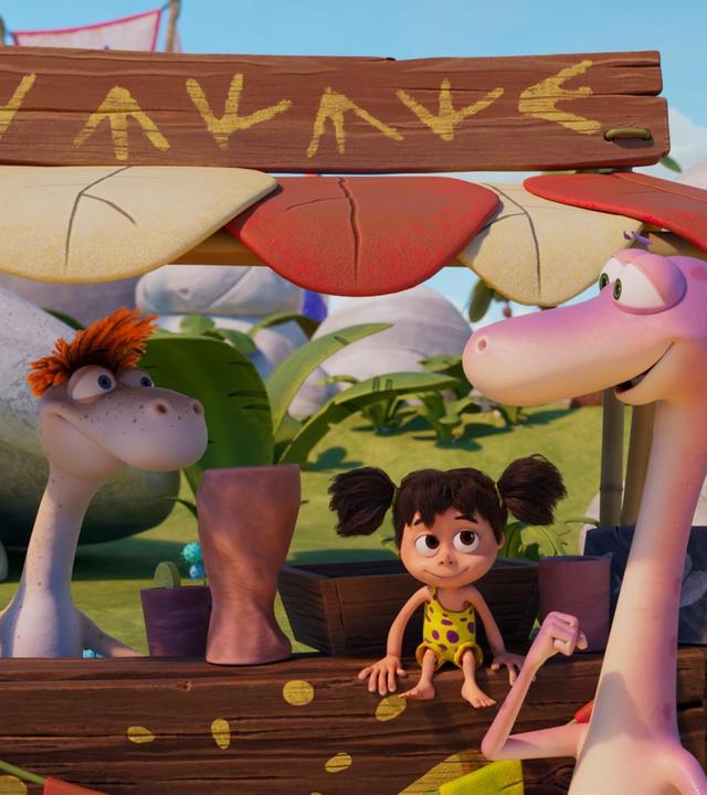 Der rosafarbene Dinosaurier Minus Drei steht an einem hölzernen Verkaufsstand. Über dem Stand sind nicht lesbare Zeichen. Flint, sein Freund mit den orangefarbenen Haaren, scheint Limonade zu verkaufen. Man sieht einen Becher mit Zitrone und einen großen tönernen Krug auf dem Tresen. Und das Menschenmädchen Lucy sitzt ebenfalls auf dem Tresen.