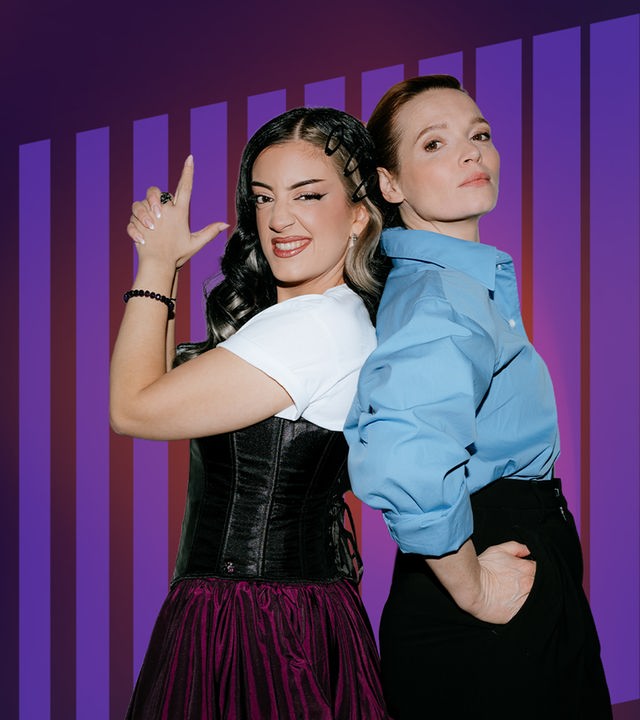 Parshad und Karoline Herfurth stehen Rücken an Rücken und Parshad simuliert mit den Händen eine Pistole.