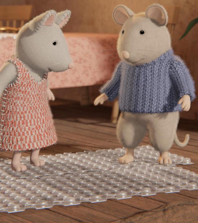 Julia und Sam stehen mit fröhlichen Gesichtern auf einer Luftpolsterfolie in der Wohnung von Oma Gouda. Sie scheinen die Blasen mit den Füßen zu zerdrücken. Hinter ihnen auf einem Tisch liegt eine weitere Folie und darauf liegt ein Hörrohr.