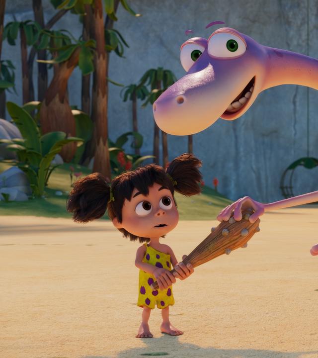 Der rosafarbene Dinosaurier Minus Drei berührt mit einer Hand die Keule von seiner Freundin Lucy. Lucy hält die Keule in der Hand und schaut fragend.