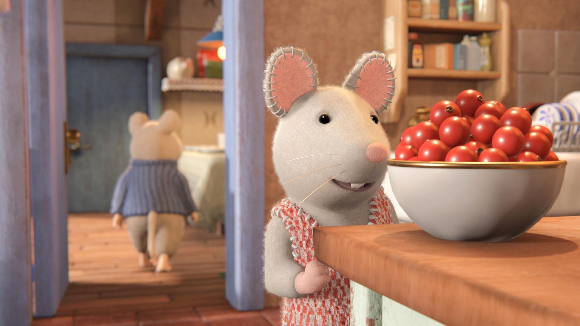 Julia steht in der Küche vor einer Schüssel mit roten Beeren auf einem Tisch und schaut sie begehrlich an. Hinter ihr verlässt Sam gerade die Küche. Er ist von hinten zu sehen und geht auf einen Tisch im Nebenraum zu.