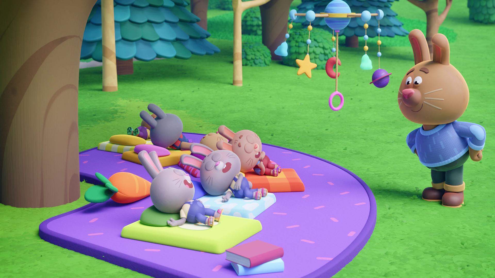 Auf einer lilafarbenen Picknick-Decke schlafen sechs kleine Hasen. Sie liegen mit geschlossenen Augen und offenen Mündern auf bunten Matratzen. Über ihnen - am Ast eines Baumes - hängt ein Mobile. Das Ganze schaut sich Papa Rüdi auf der Seite stehend an und scheint glücklich, dass seine Häschen eingeschlafen sind.