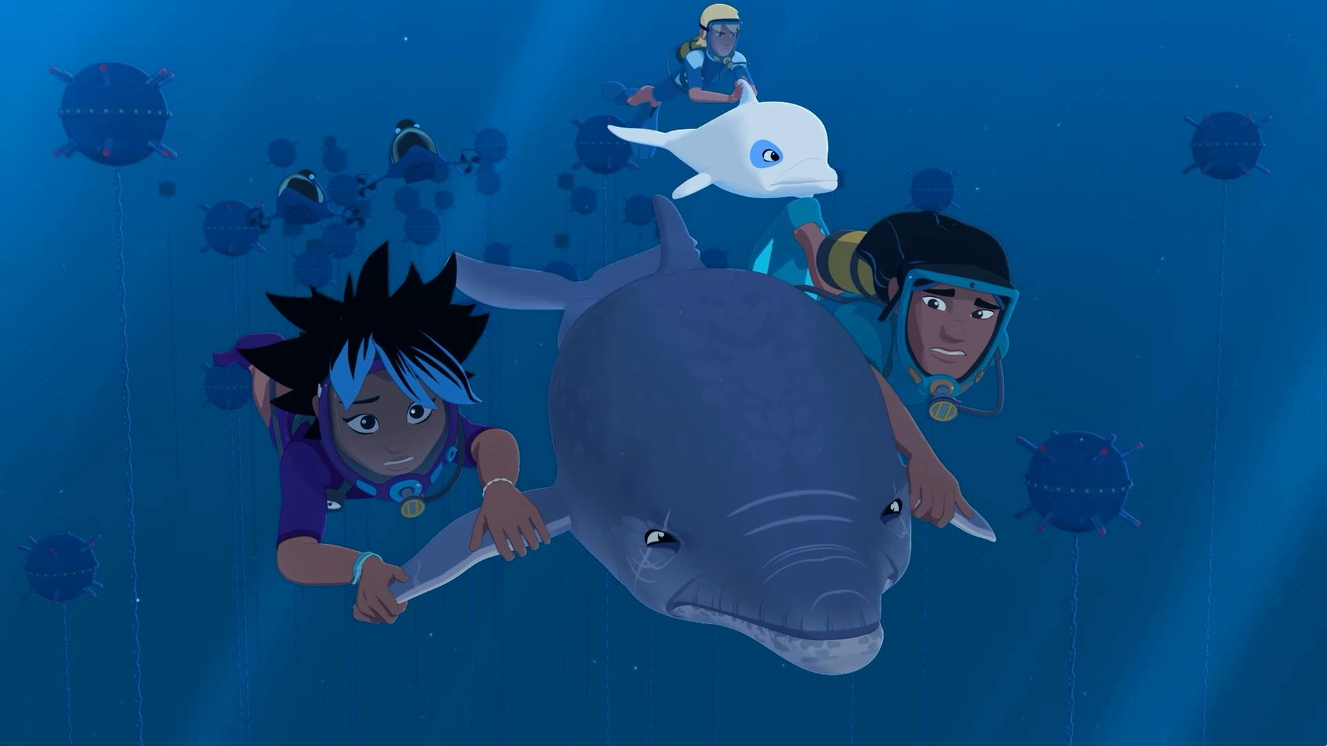 Unter Wasser im Meer: Maimiti und Auru halten sich an den Flossen von Delfin Igor fest, der sie durchs Wasser zieht. Ihnen folgen Yann und Zoom. Yann sitzt auf dem Rücken von Delfin Zoom. Um sie herum sind Unterwasserdrohnen und einigen Unterwasserminen.