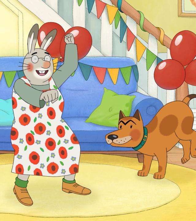Im Wohnzimmer tanzen Monika, Oma Karlchen, Karlchen und Bello. Karlchen bläst auf einer Party-Tröte, Monika klatscht in die Hände, Bello hebt die Hinterbeine und Oma macht wilde Tanzbewegungen.