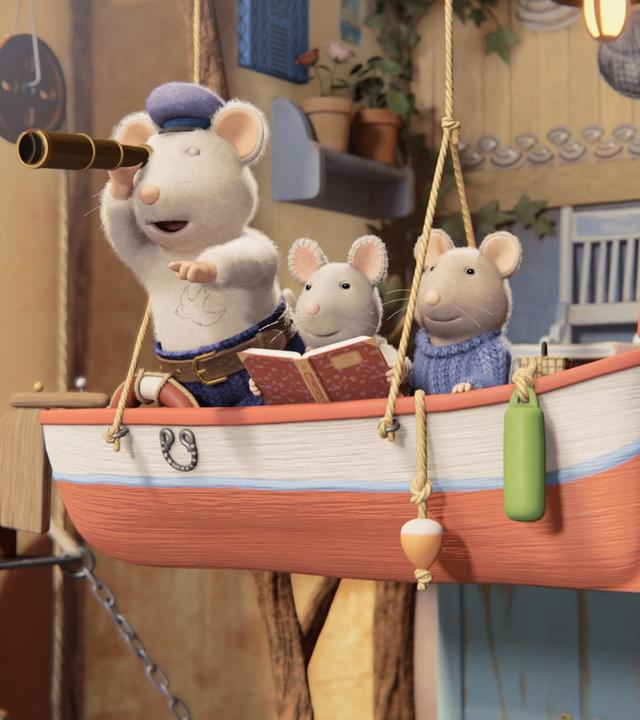Opa Seemann steht mit einem Fernrohr, das er sich vor das rechte Auge hält, in einem Boot. Das Boot ist vor dem Mäusehaus mit Seilen an der Decke aufgehängt. Neben Opa Seemann sitzen Julia und Sam und schauen ebenso wie er in die Ferne. Julia hält ein offenes Buch in ihren Händen.