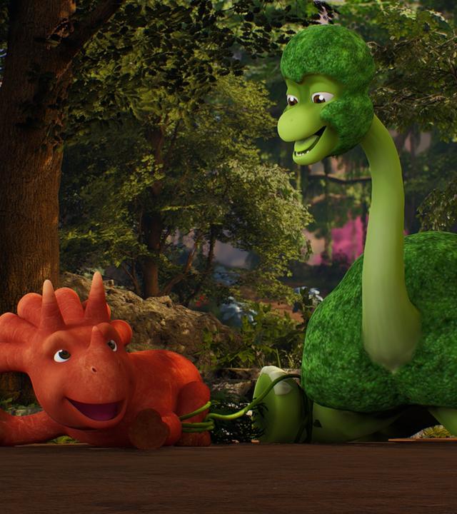 Im Bild liegen - die Beine von sich gestreckt - das Trikarottops-Mädchen Ginger und ein Brokkolisaurier nebeneinander. Sie sind mit einem grünen Seil zusammengeknotet an den Beinen. Sie lachen sich gegenseitig an. (Ginger ist ein Wesen, das einer Karotte ähnelt und ein Brokkolisaurier schaut wie ein grüner Brokkoli aus.)