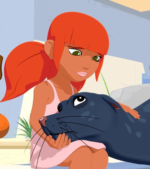 Marina sitzt am Rand eines Wasserbeckens. Seelöwin Daisy liegt neben ihr und hat ihren Kopf auf Marinas Schoß gelegt. Marina streicht mit der linken Hand über den Rücken des Tieres. Beide schauen einander traurig an. Im Hintergrund steht ein Gebäude.