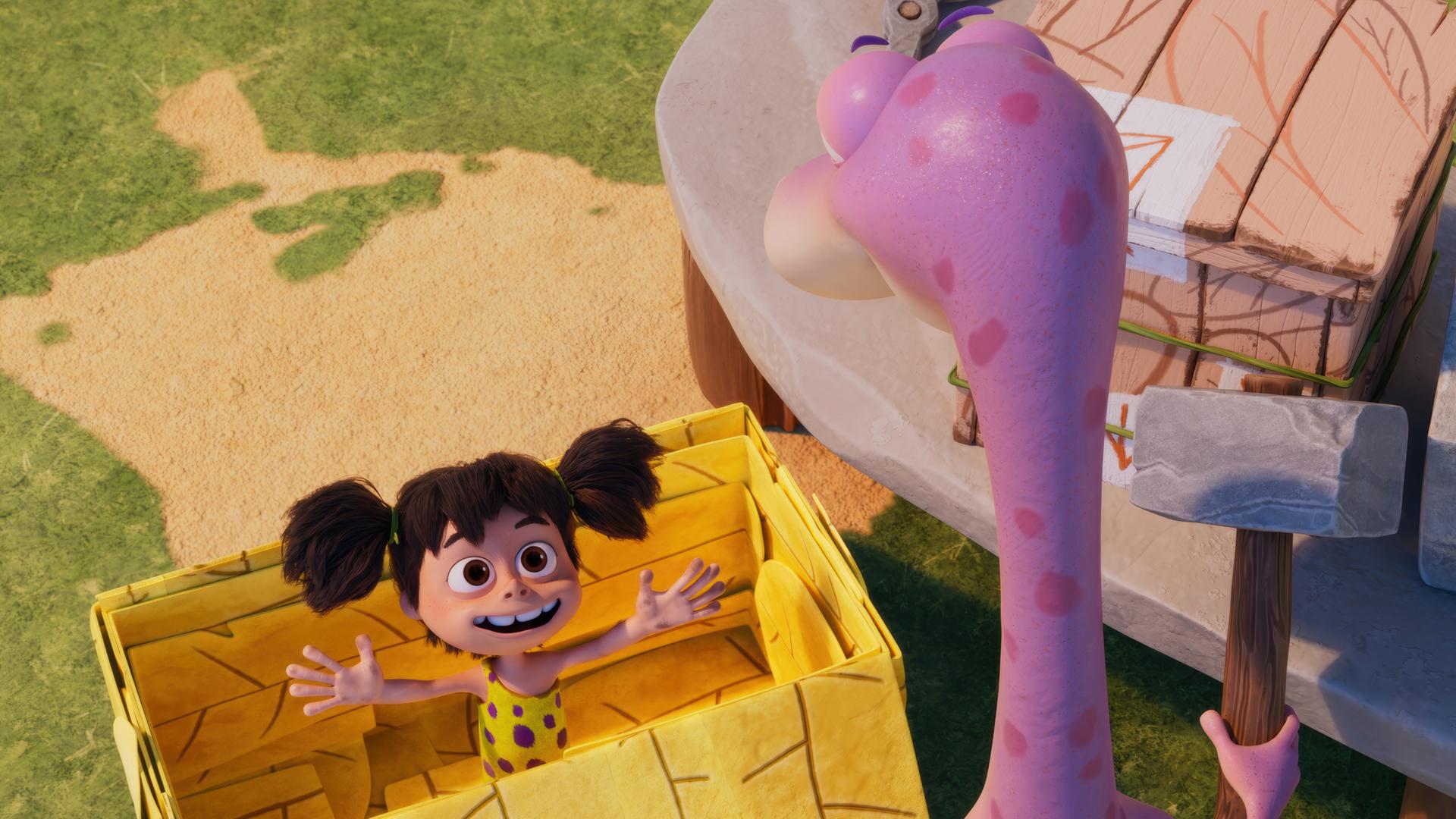 Das Urzeitmädchen Lucy steht mit ausgebreiteten Armen in einer gelben Pappkiste. Minus Drei - mit dem Rücken zu uns - betrachtet seine Freundin in der Kiste.