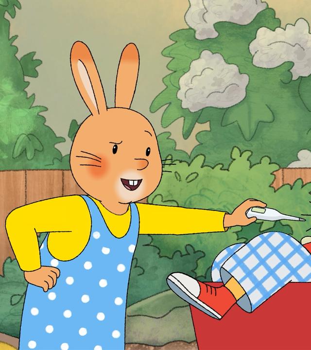 Karlchen und Monika sind im Garten. Monika hält ihm ein Fieberthermometer entgegen. Karlchen sitzt in einem roten Bollerwagen, sein Fuß hängt raus.