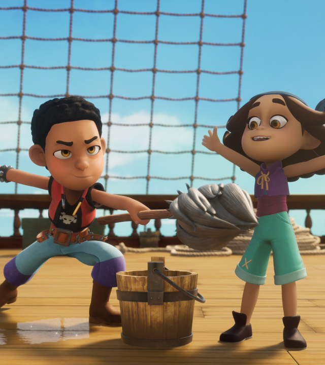 Der Piratenschüler Finn steht auf Deck in einer großen Wasserpfütze und hat einen Wischmop in der Hand. Vor ihm steht ein Eimer Wasser. Im Spiel zeigt er angriffslustig mit dem Wischmop auf Sina, die ergeben ihre Hände zur Seite ausgebreitet hat.