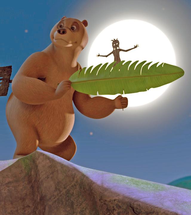 Baghira hält eine Holzfigur im Mund. Balu hat eine Figur unter den rechten Arm geklemmt und hält mit beiden Vorderpfoten ein Bananenblatt und eine Figur fest. Hinter ihm scheint der Vollmond.