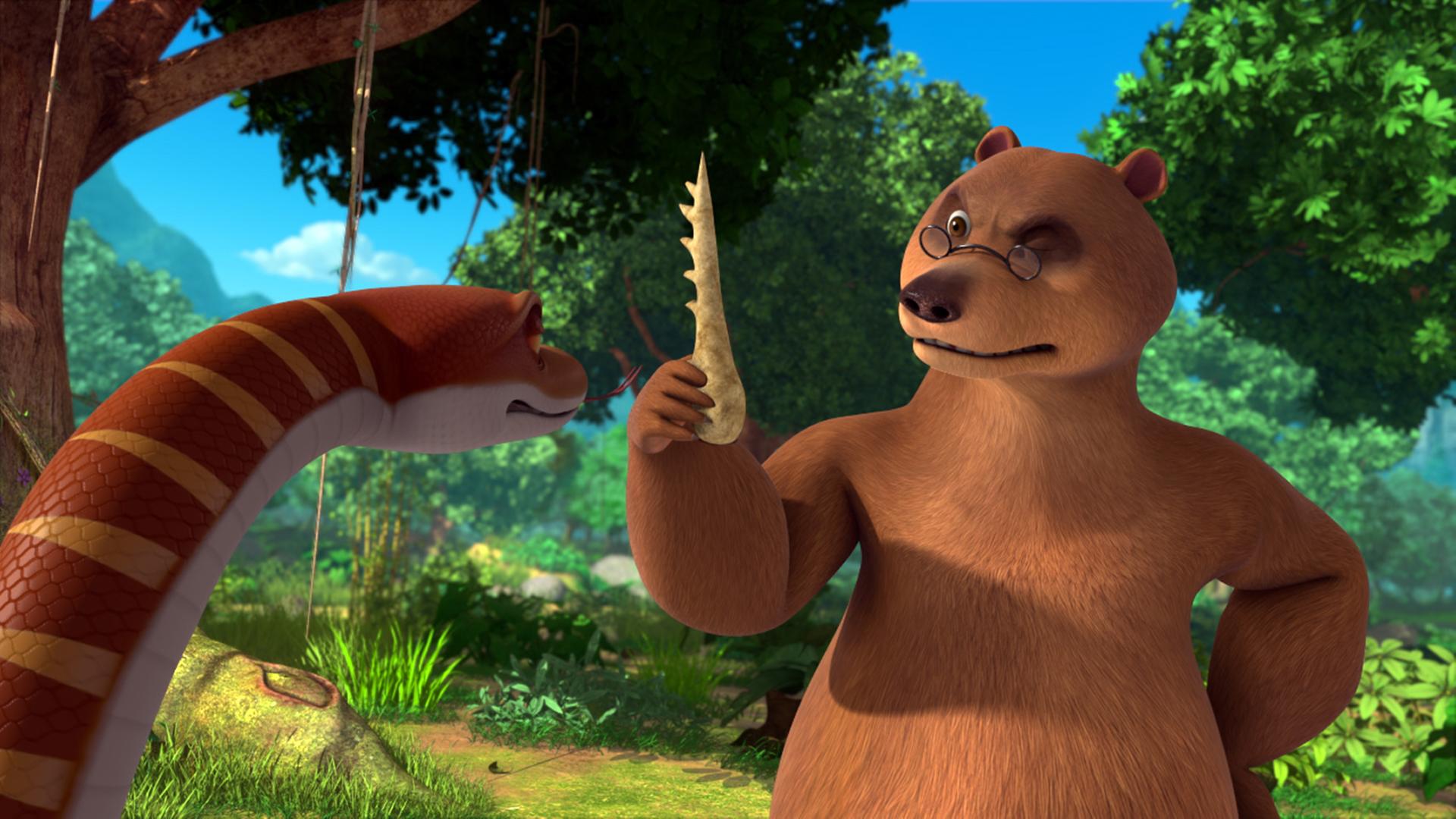 Balu hält den Knochenkamm in der rechten Hand und betrachtet ihn kritisch. Kaa sieht den Kamm auch an.