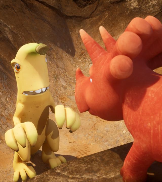 Unten in einem tiefen, hellbraunen Loch stehen die zwei Bananaraptoren und schauen bittend. Bananaraptoren sind Wesen, die aussehen wie gelbe Bananen mit Gesicht und Armen und Beinen aus kleineren Bananenstauden. An der Kante des Loch steht Ginger, das orangefarbene Trikarottops-Mädchen, das einer Karotte ähnelt. Sie hat uns den Rücken zugedreht und schaut hinab ins Loch.