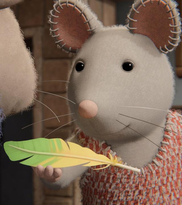 Julia steht vor Sam und hält mit ihrer rechten Hand eine Feder hoch, die zur Hälfte gelb, zur Hälfte grün ist.  Beide schauen aufmerksam auf die Feder.