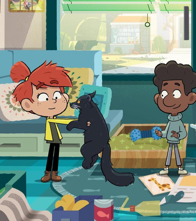 Ein rothaariges Mädchen hält in einem unaufgeräumten Zimmer einen Marderbären in Händen. Ein Schwarzer Junge steht freudig lächelnd daneben.