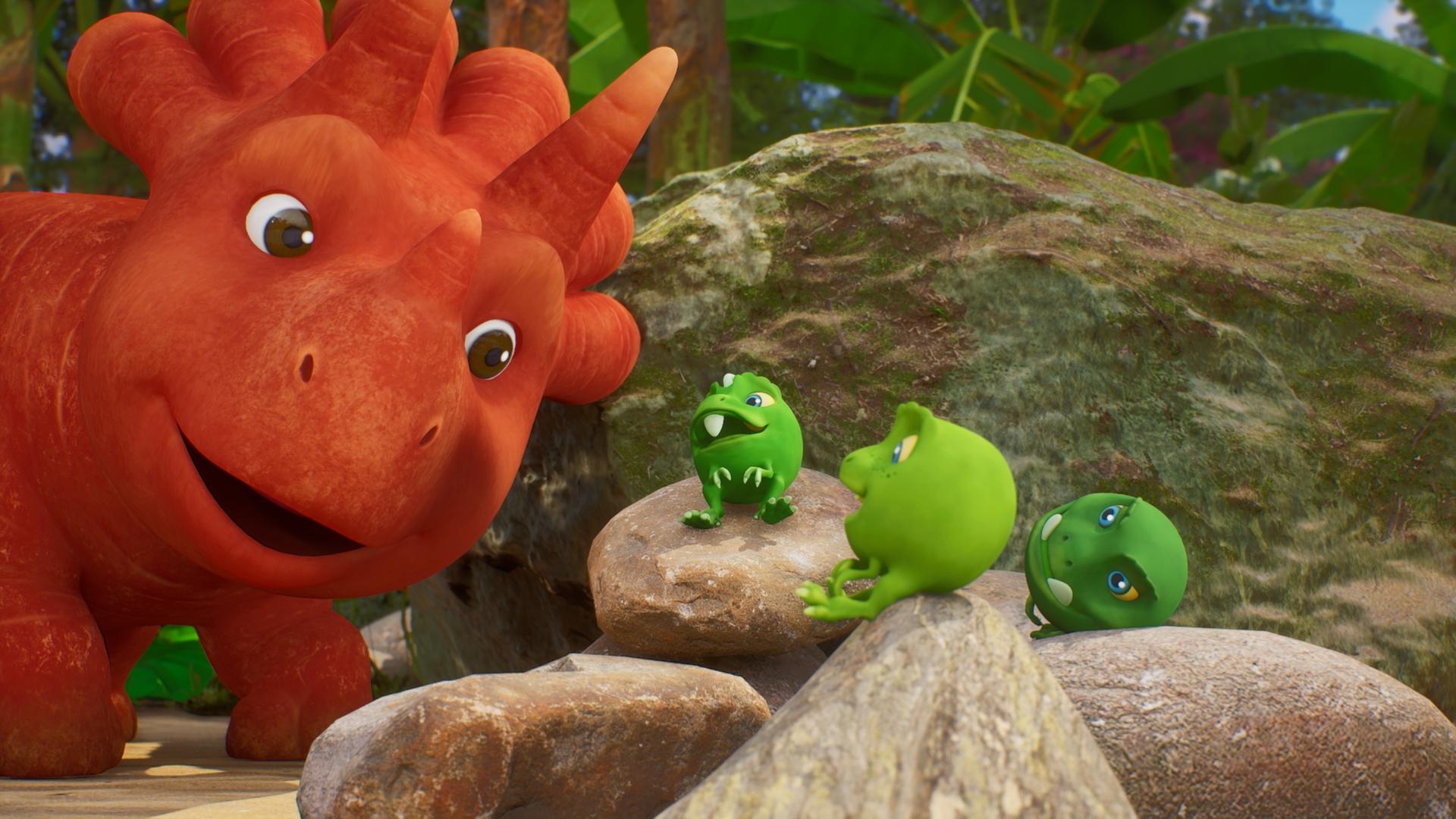 Im Bild sehen wir drei Erbs-Rexe auf Steinen herumliegen. (Erbs-Rexe sind Wesen, die aussehen wie Erbsen mit Gesichtern und Ärmchen und Beinchen.) Sie scheinen Ginger zuzuhören, die von links mit ihrem Kopf ins Bild ragt und den Mund offen hat. Ginger ist ein Trikarottops-Mädchen und sieht aus wie eine Karotte mit Gesicht.