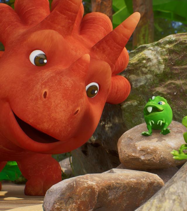 Im Bild sehen wir drei Erbs-Rexe auf Steinen herumliegen. (Erbs-Rexe sind Wesen, die aussehen wie Erbsen mit Gesichtern und Ärmchen und Beinchen.) Sie scheinen Ginger zuzuhören, die von links mit ihrem Kopf ins Bild ragt und den Mund offen hat. Ginger ist ein Trikarottops-Mädchen und sieht aus wie eine Karotte mit Gesicht.