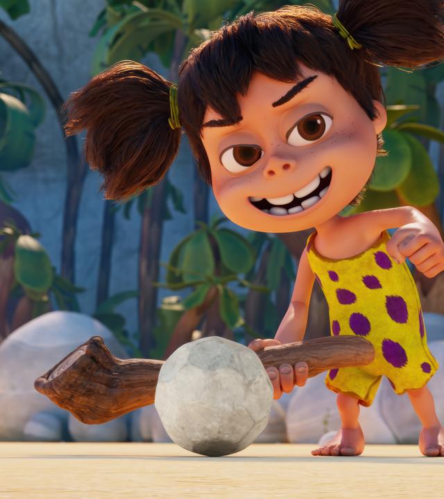 Das Steinzeitmädchen Lucy hält einen Stock wie einen Golfschläger in der Hand. Vor ihr liegt ein steinerner Golfball. Sie grinst, als würde sie den Ball mit einem Schlag einlochen.