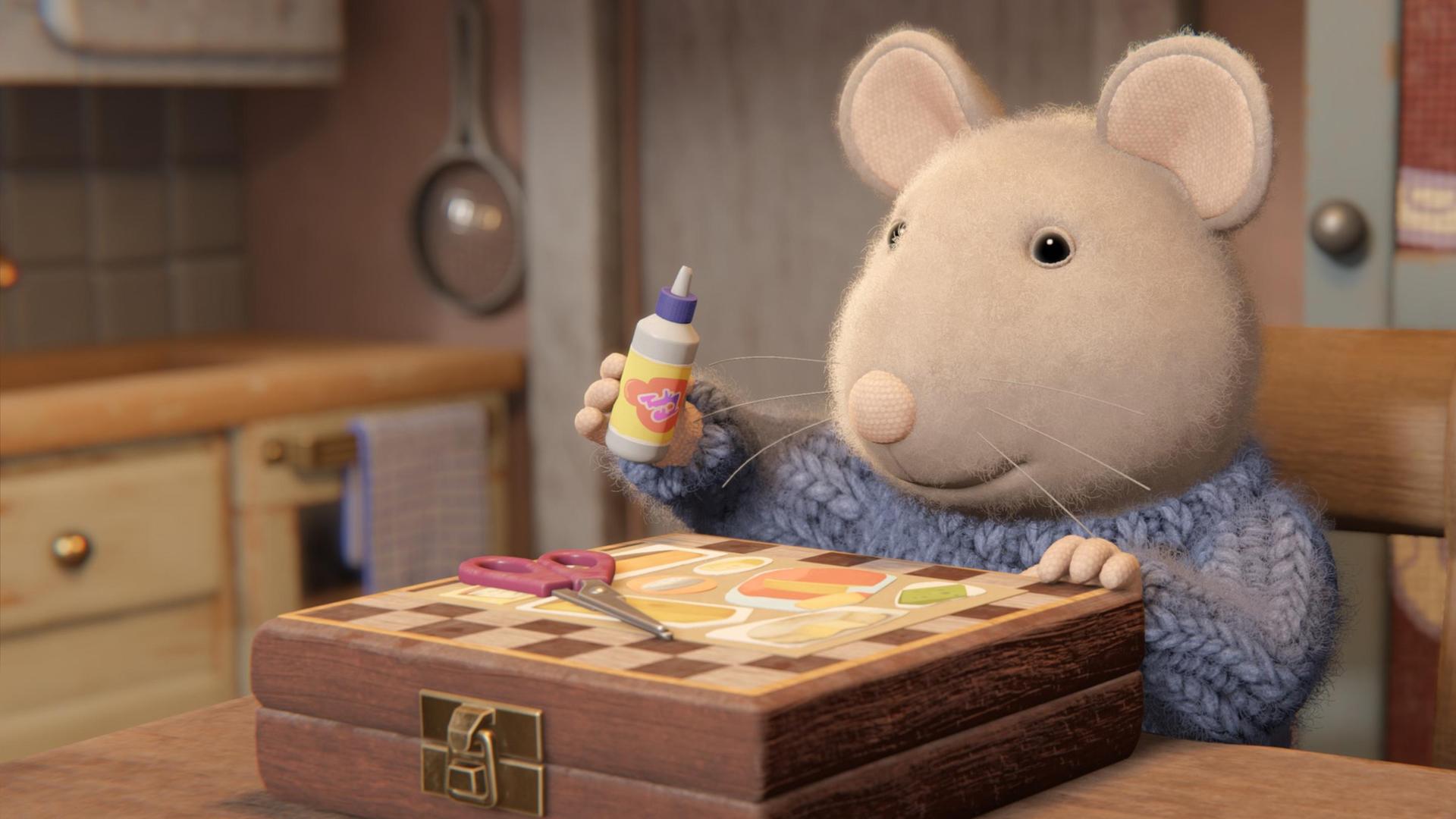 Sam sitzt in einer Wohnung auf einem Holzstuhl an einem Holztisch. Vor ihm auf dem Tisch liegt ein Schachbrettkasten. Darauf liegen ein Bild und eine Schere. Sam hält eine Flasche mit Flüssigkleber in der rechten erhobenen Hand und schaut auf das Bild vor sich.