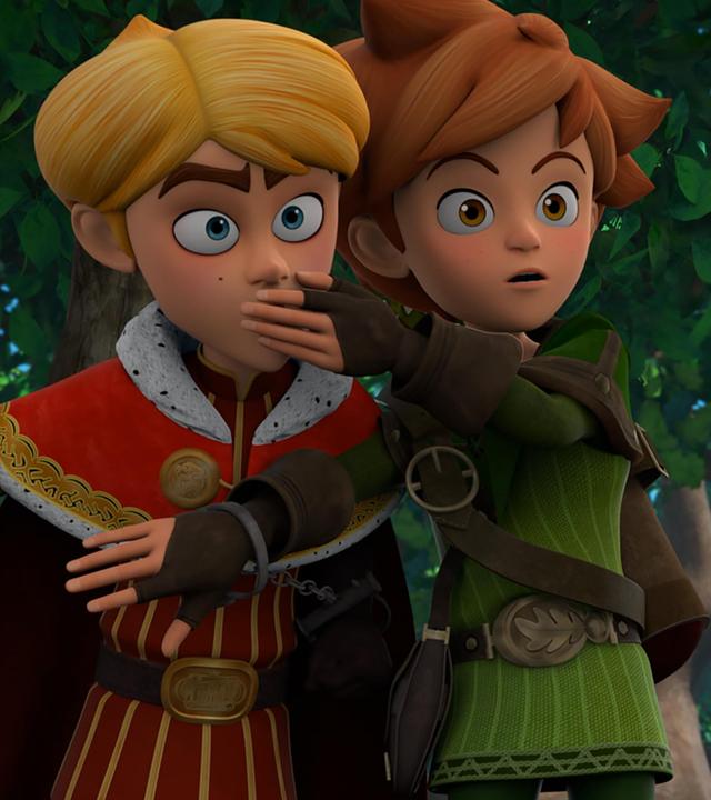 Prinz John und Robin sind aneinander gekettet und stehen nebeneinander im Wald. Robin hält seine linke Hand vor den Mund von Prinz John, damit er sich still verhält.