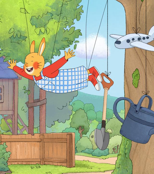 Karlchen hängt mit ausgebreiteten Armen an Schnüren, die an einem Baum befestigt sind. An Schnüren hängen auch ein Fußball, ein Spaten, eine Gießkanne und ein Spielzeugflugzeug. Karlchens Papa schaut skeptisch auf seinen an Sohn. 