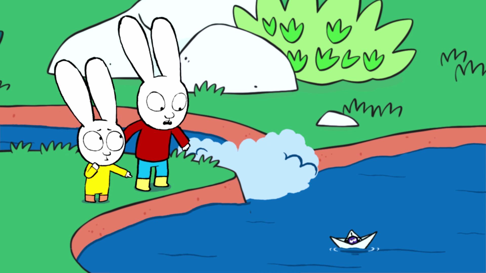 Simon und Franz stehen an einem Teich mit Bachzulauf. Auf dem Teich schwimmt ein kleines Faltboot, in dem eine Spinne sitzt. Simon schaut besorgt zu dem Faltboot. Franz schaut fragend zu Simon und zeigt mit seinem Finger auf die Spinne.