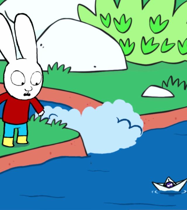 Simon und Franz stehen an einem Teich mit Bachzulauf. Auf dem Teich schwimmt ein kleines Faltboot, in dem eine Spinne sitzt. Simon schaut besorgt zu dem Faltboot. Franz schaut fragend zu Simon und zeigt mit seinem Finger auf die Spinne.