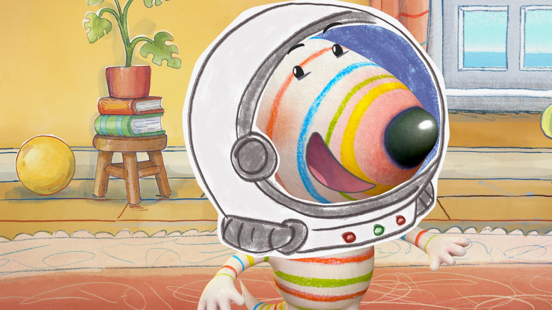 Hund Dylan steht in kompletter Astronautenmontur im Wohnzimmer. Er trägt einen Astronautenanzug mit Helm. Besonders auffällig ist ein großer, mechanischer Greifarm, den Dylan hochhält.