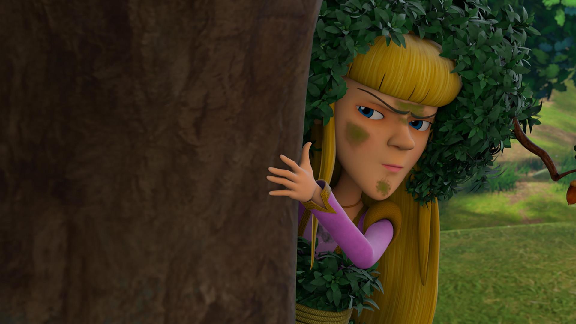 Nelly versteckt sich hinter einem Baum, hält sich mit der linken Hand am Stamm fest und beobachtet kritisch. Ihr Gesicht ist mit grünen Flecken beschmiert und sie trägt zur Tarnung Blätter auf ihrem blonden Haar.