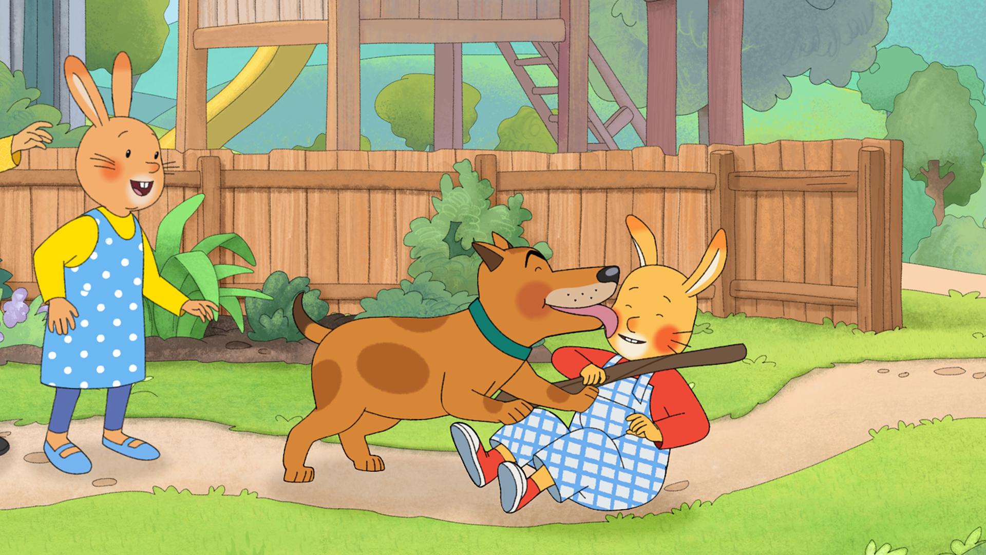 Karlchen liegt am Boden im Vorgarten. Er hält ein Stöckchen in der Hand für Hund Bello, der ihn gerade mit seiner Zunge abschleckt. Links neben den beiden stehen Monika und ihre Mama, lachend.