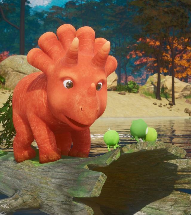 Das Trikarottops-Mädchen Ginger, eine Karotte, die aussieht wie ein Dinosaurier, steht auf einem hohlen Baumstamm und treibt auf einem See. Ganz vorne auf dem Baumstamm stehen die drei Erbs-Rexe. Erbs-Rexe sind Erbsen, die aussehen wie Dinosaurier mit kleinen Ärmchen und Beinchen. Im Hintergrund ist das Ufer des Sees zu sehen und viele Bäume und Sträucher mit orangefarbenen Blättern.