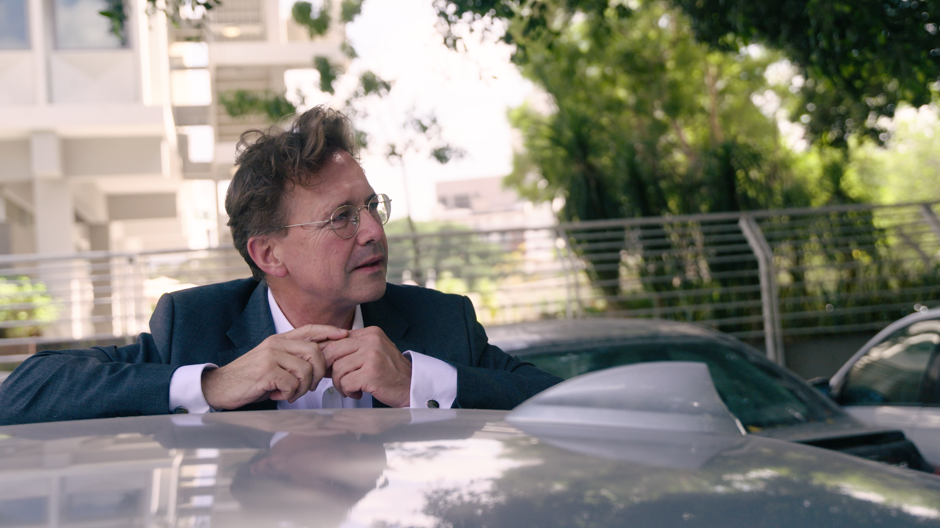 ein Mann mit Brille ander Seite eines PKW