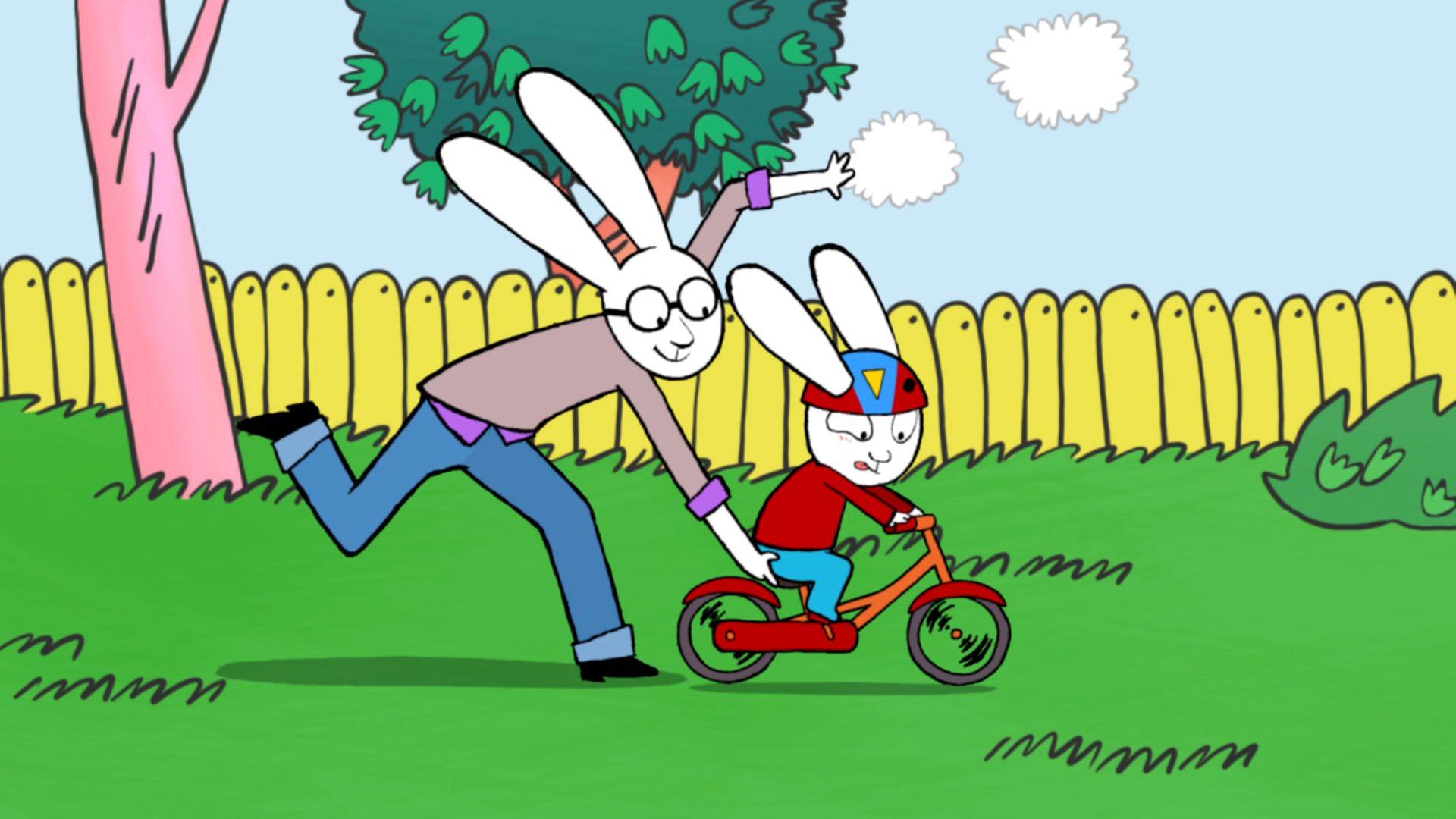 Simon, mit einem Fahrradhelm auf dem Kopf, fährt hastig mit seinem Fahrrad durch den Garten. Papa hält das Fahrrad am Sitz fest und läuft gemeinsam mit Simon durch den Garten.