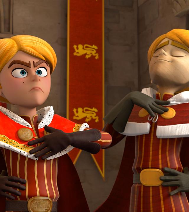 Im Schloss steht Prinz John mit stolz hervorgestreckter Brust und gerader Haltung vor seinem Thron. Er nimmt eine hoheitsvolle Geste an. Neben ihm steht eine lebensechte Statue von ihm.