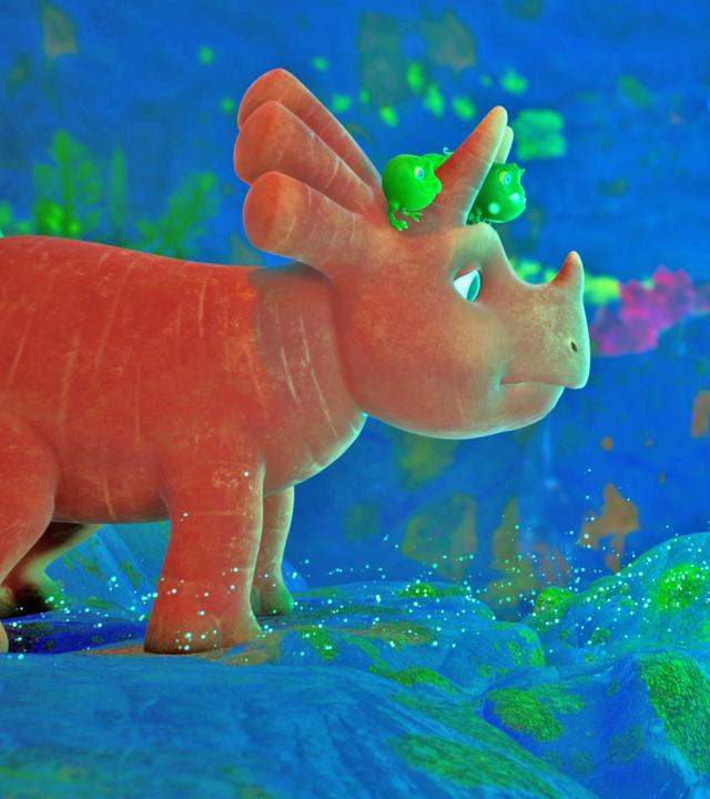 Ginger ist ein Dinosaurier-Mädchen, das einer Karotte ähnelt. Sie steht unter Wasser auf dem Grund eines tiefblauen Sees und betrachtet ein Loch, aus dem Blubberbläschen aufsteigen.