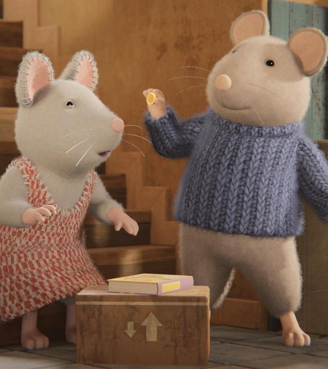 Sam steht im Treppenhaus vor einer Treppe mit Geländer und hält eine Münze mit seiner rechten Hand hoch. Julia sitzt auf der untersten Stufe und schaut zu Sam. Vor den beiden steht eine Kiste, auf der ein Buch liegt. Neben dem Treppenaufgang steht eine Kommode neben einem Büffetschrank.