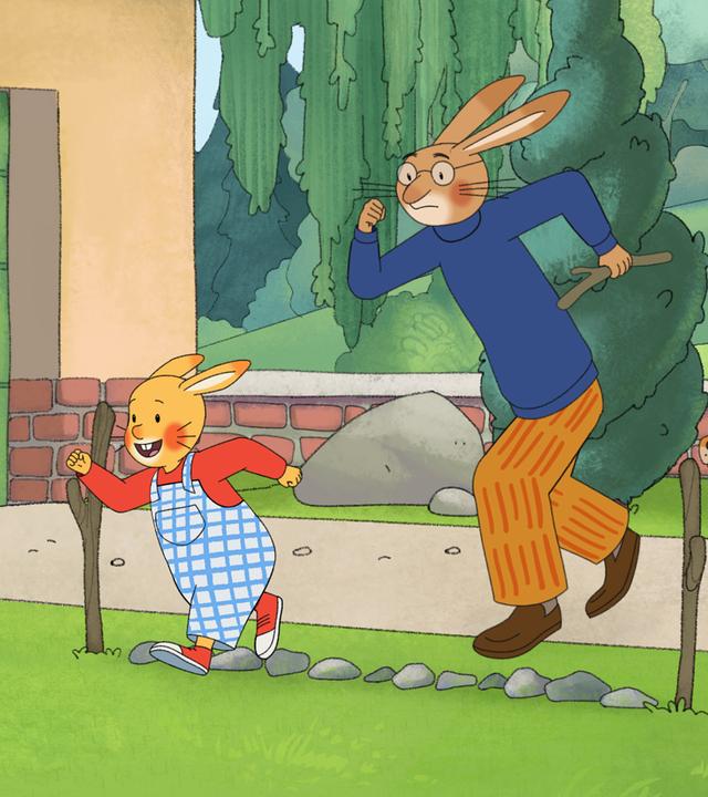 Karlchen und sein Vater stehen im Garten an einer Startlinie aus Steinen. Hinter ihnen sitzt Bello und wartet darauf, dass das Rennen beginnt. 