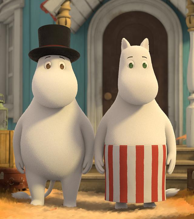 Muminpapa und Muminmama stehen vor dem Haus der Mumins. Um sie herum stehen viele Kisten und Kartons, die die beiden für den Umzug vorbereitet haben.