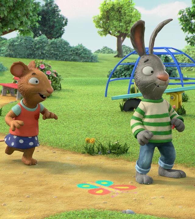 Das Kaninchen Pip steht auf einem Weg und schaut fröhlich lachend nach vorne. Neben ihm ist eine bunte Zeichnung eines Schmetterlings zu sehen. Hinter ihm befindet sich seine Freundin Posy, die Maus, die in rennender Bewegung und fröhlich lachend auf ihren Freund zukommt.