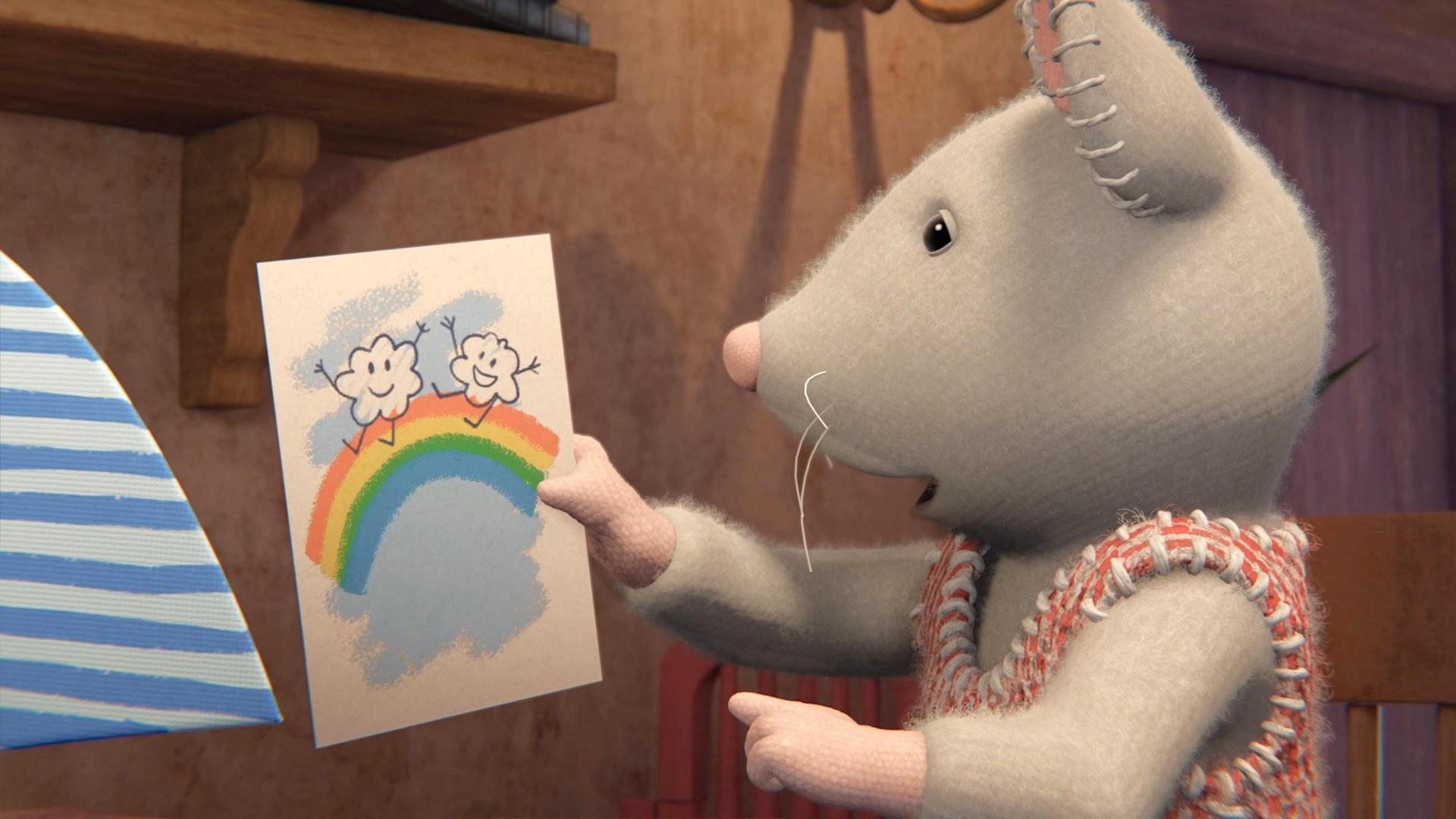 Julia hält ein selbst gemaltes Bild hoch, auf dem ein Regenbogen zu sehen ist, über dem zwei Wolken fröhlich tanzen. Sie schaut das Bild nachdenklich an.