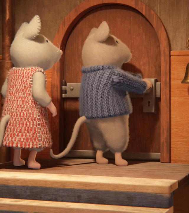 Julia und Sam stehen oben auf dem Treppenabsatz einer Treppe vor einer Tür mit Rundbogen. Sam versucht die Tür zu öffnen.  Beide stehen zur Tür gewandt und schauen besorgt auf das Schloss.