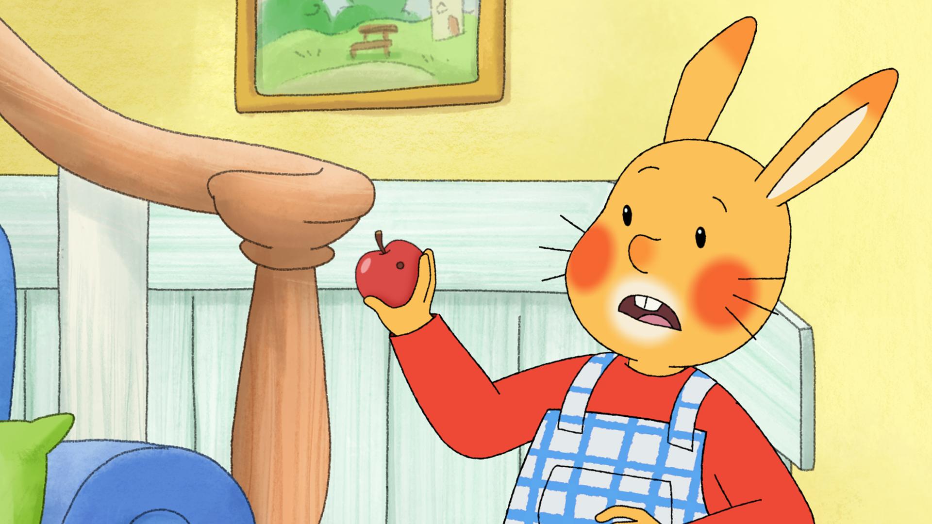 Karlchen steht im Wohnzimmer und hält einen Apfel in der Hand. Er macht ein erschrockenes Gesicht, denn im Apfel ist ein Wurmloch!