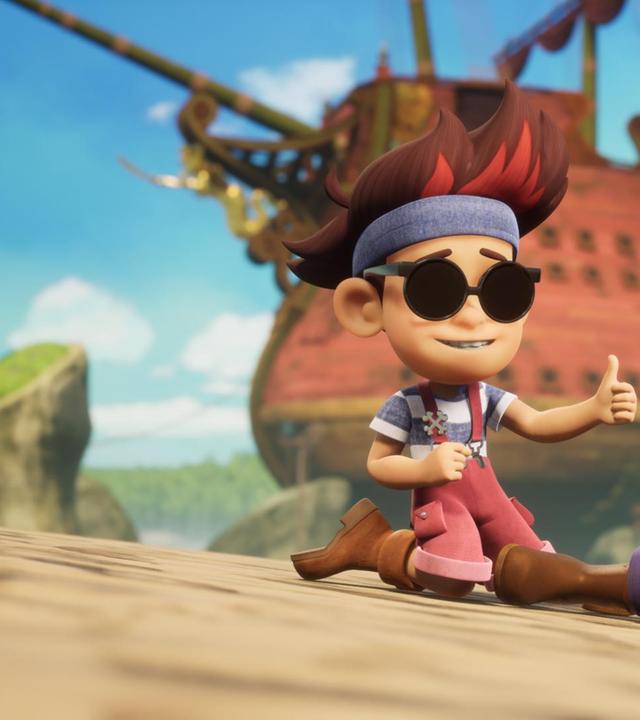 Finn liegt seitlich auf dem Boden und stützt sich mit einem Arm und angewinkelten Beinen ab. Seine rechte Hand hält er direkt vor sein Gesicht und hat dabei die Augen geschlossen. Vor ihm kniet Raul und zeigt Finn mit ausgestrecktem Arm einen Daumen hoch. Hinter den beiden sieht man das Schulschiff Galeone.