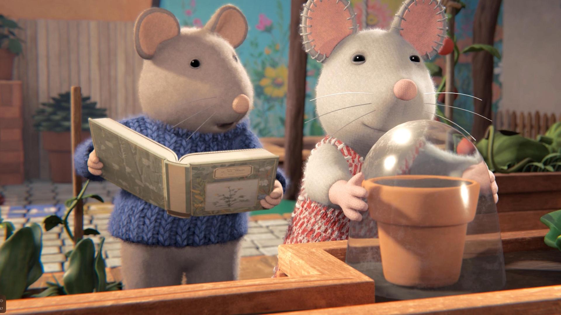 Sam und Julia stehen vor einem Regal auf der Terrasse. Dort steht ein Blumentopf, über den Julia eine Glasglocke stülpt. Sam steht neben ihr und hält ein geöffnetes Buch in der Hand. Er erzählt Julia etwas.