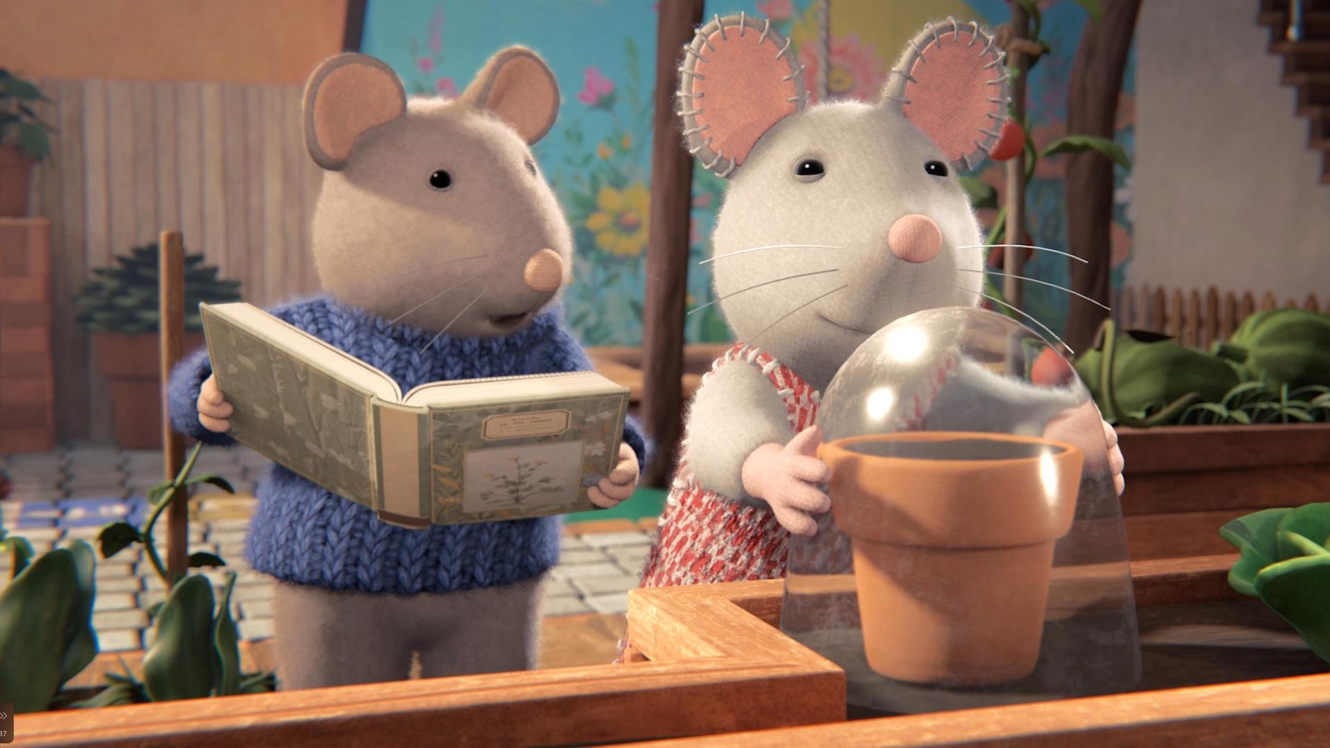 Sam und Julia stehen vor einem Regal auf der Terrasse. Dort steht ein Blumentopf, über den Julia eine Glasglocke stülpt. Sam steht neben ihr und hält ein geöffnetes Buch in der Hand. Er erzählt Julia etwas.