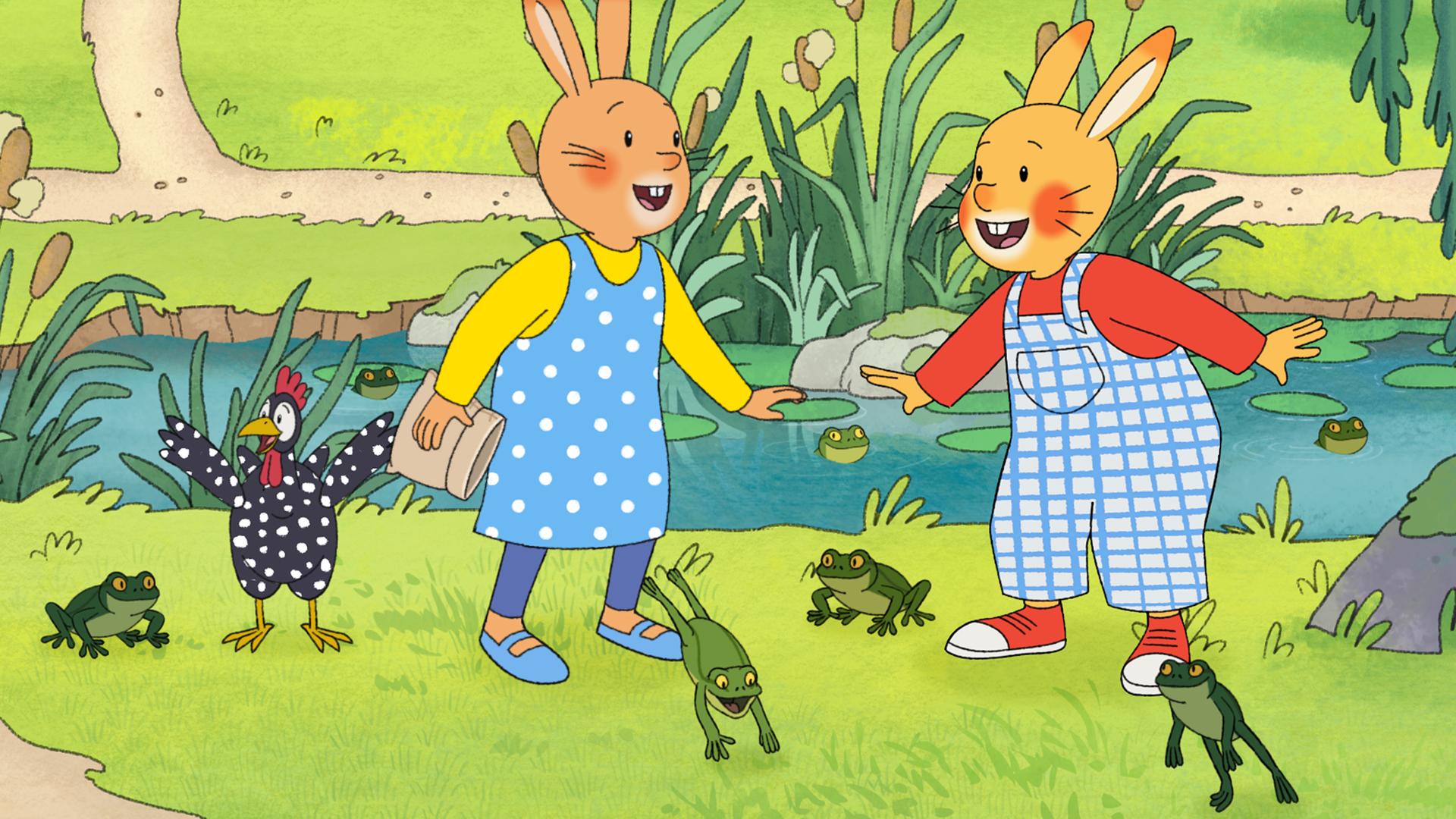 Vor einem Froschteich stehen Monika und Karlchen und lachen sich an. Um sie herum hüpfen viele grüne Frösche. Auch Perlhuhn steht dabei. 