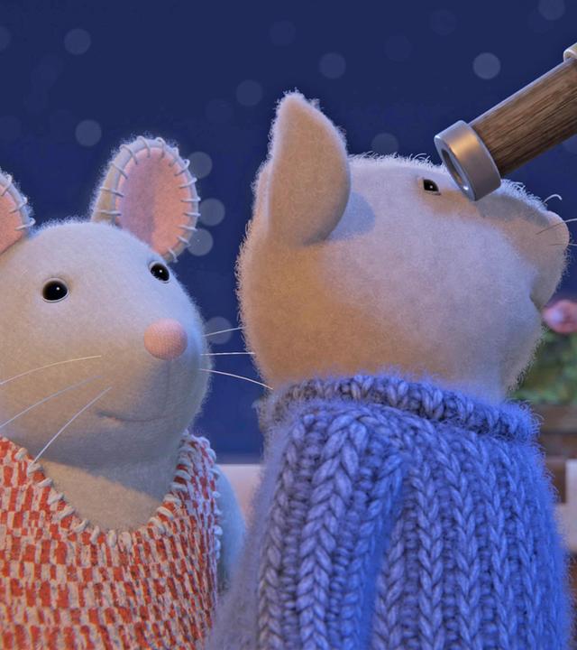 Sam schaut durch ein Teleskop in den Nachthimmel, während Julia ebenfalls auf der Terrasse hinter ihm steht und darauf zu warten scheint, auch hindurchschauen zu dürfen.