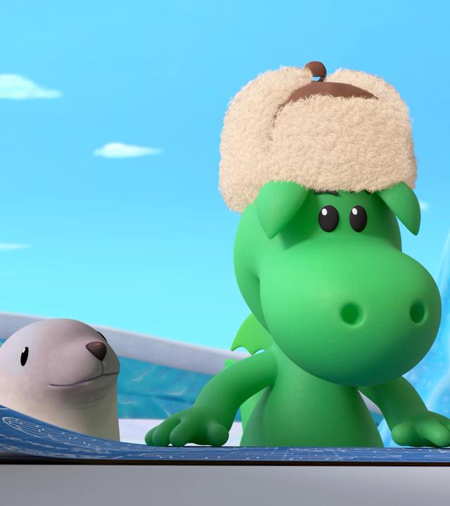 Der kleine Drache Grisu trägt eine warme, gefütterte Wintermütze. Er betrachtet eine blaue Skizze, die vor ihm liegt. Neben ihm ist ein kleiner Seelöwe, der ihm zuschaut.