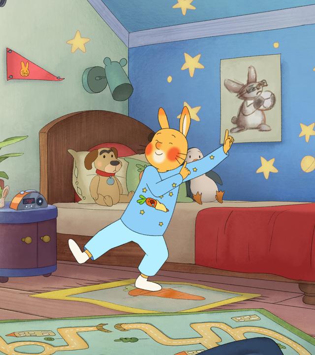Der Kaninchenjunge Karlchen steht tanzend in seinem Kinderzimmer.
