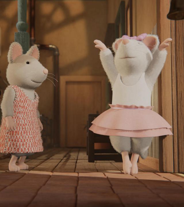 Julia steht im Flur des Treppenhauses neben Ella und schaut zu, wie Ella eine Ballettfigur tanzt. Ella hat beide Arme in die Luft gestreckt. Sie steht auf den Zehenspitzen und setzt gerade graziös den rechten Fuß vor den linken.